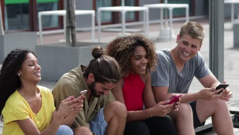 Cheerful-friends-using-smartphones